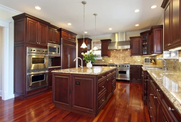 Cherry wood cabinets and flooring in a modern kitchen.