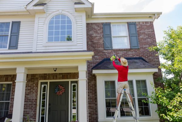 Pressure washing a hard to reach soffit on a two story home.