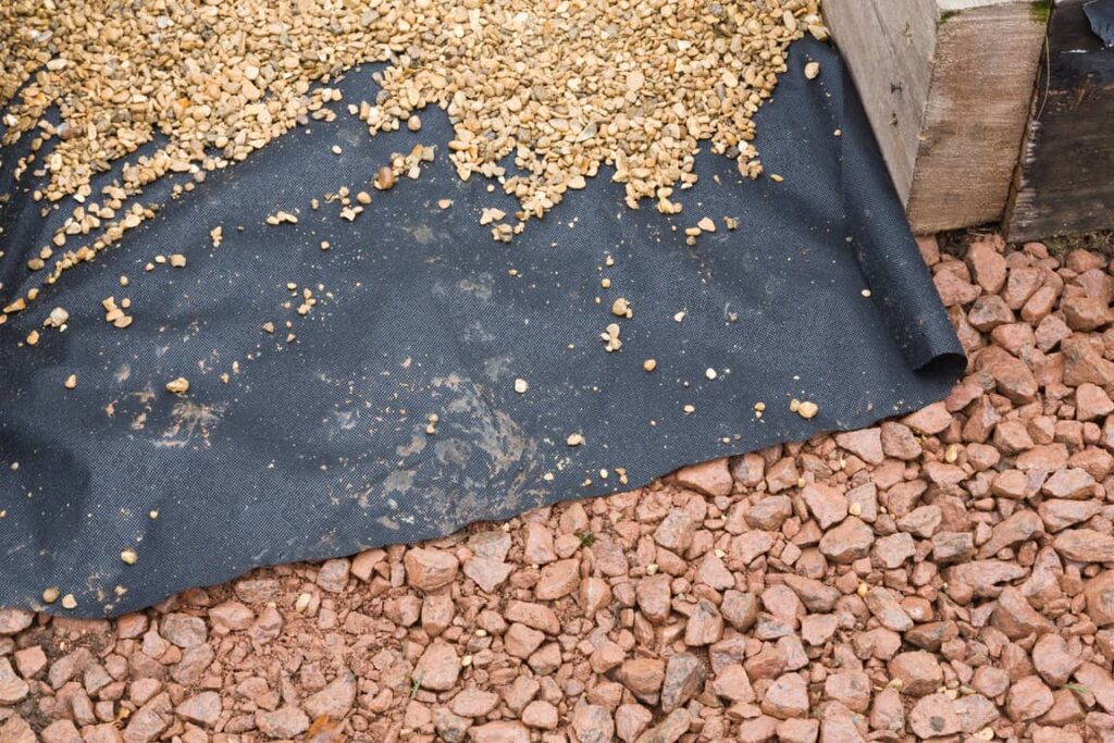 Gravel on landscape fabric. 