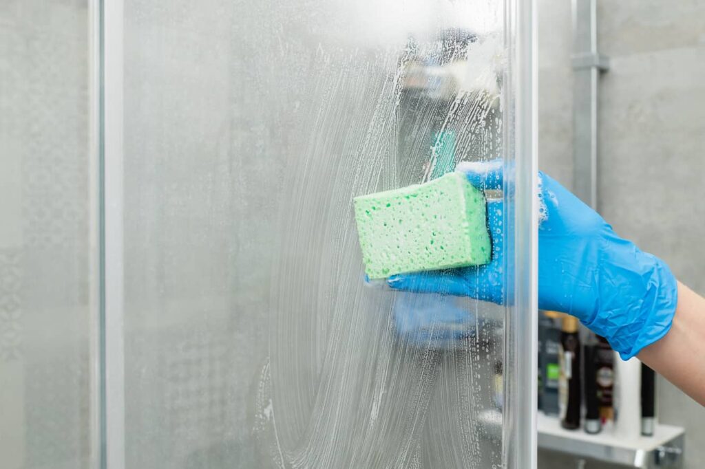 Use a variety of solutions to scrub away water spots on glass shower doors. 