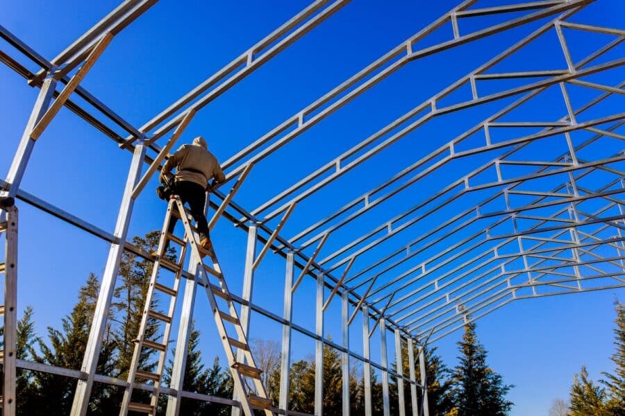 Stainless steel roof structure for future roof under construction. Development of metal roofing frame on homes.