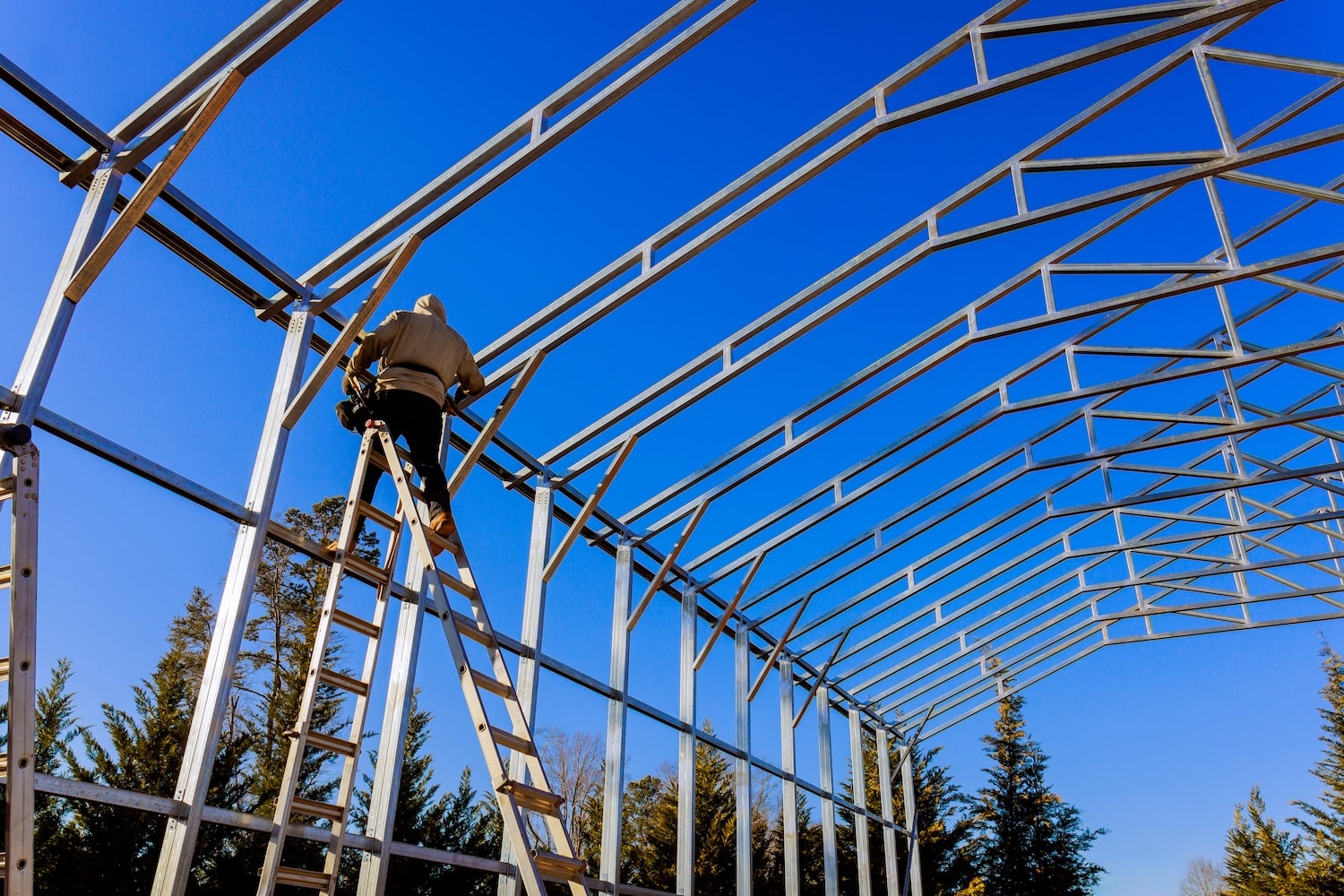 Stainless steel roof structure for future roof under construction. Development of metal roofing frame on homes.
